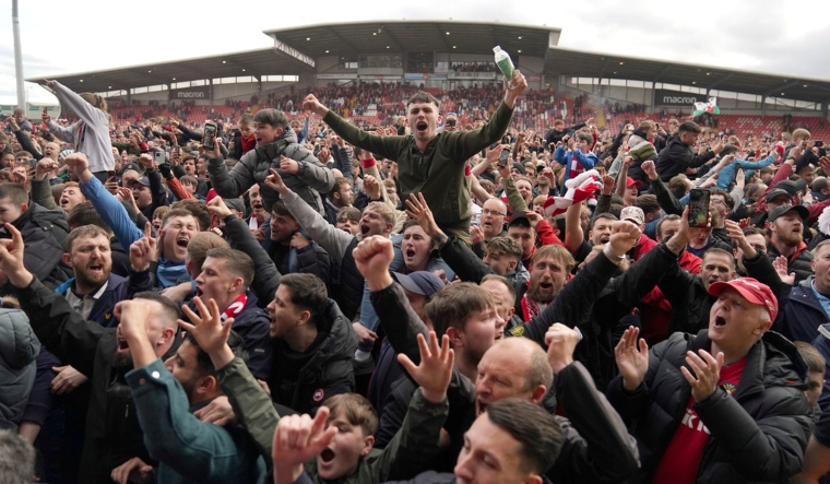 Wrexham fans invade the pitch celebrating promotion to League One | AP